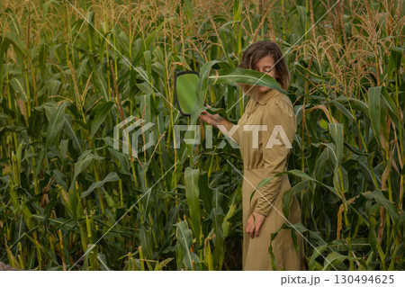 Young happy smiling woman in a green corn field in summer Young happy smiling woman in a green corn field in summer 130494625