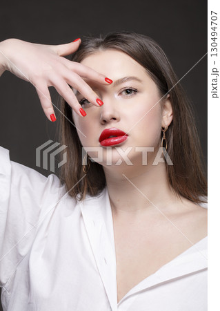 Red sexy lips and nails close-up. Manicure and makeup. Beautiful face model girl isolated on black background Red sexy lips and nails close-up. Manicure and makeup. Beautiful face model girl isolated on black background 130494707