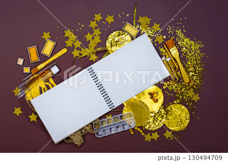 White notebook mockup for text on light backdrop. Golden stationery and materials for creativity top view. Golden art crafts 130494709