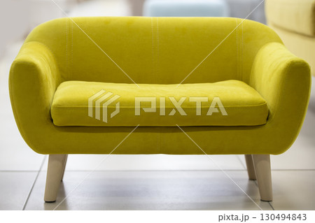 Small yellow sofa with wooden legs.Cozy sofa. Small yellow sofa with wooden legs.Cozy sofa. 130494843