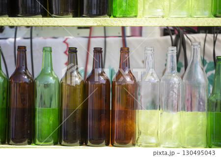 Vintage glass multi-colored bottles are in a row. Vintage glass multi-colored bottles are in a row. 130495043