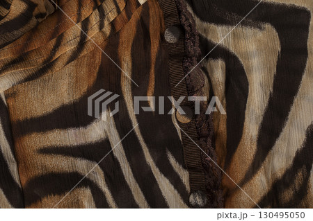 Cloth with a print of tiger stripes close-up. Drawing on the fabric of a tiger skin. 130495050