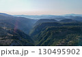 Breathtaking valley landscapes under a serene sky at dawn near the mountains showcasing nature's tranquility and beauty 130495902
