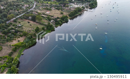 Tranquil riverside retreat showcases boats floating gently on serene waters at sunset near a picturesque village 130495911