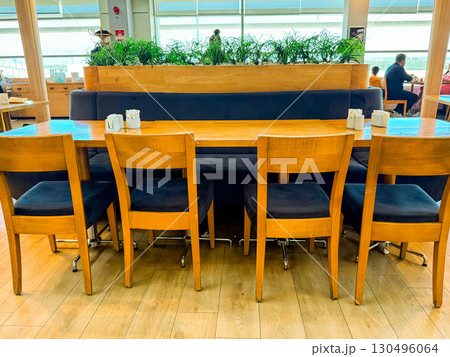 Wooden cafe table with chairs in modern interior. Social dining, hospitality, and casual lifestyle in public space. 130496064