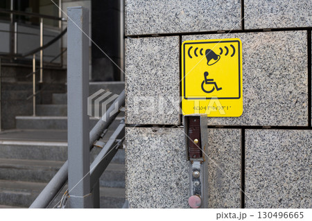 Clear and accessible sign indicating a call button for disability assistance, ensuring smooth access for people with mobility challenges in urban spaces. Essential for inclusive design 130496665