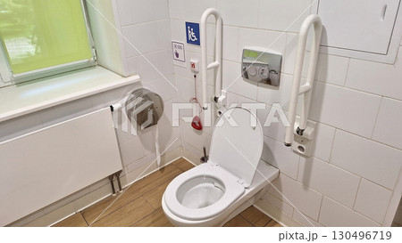 Accessible public restroom with safety rails and emergency cord 130496719