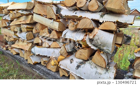 Stack of cut birch firewood logs outdoors on a summer day Stack of cut birch firewood logs outdoors on a summer day 130496721