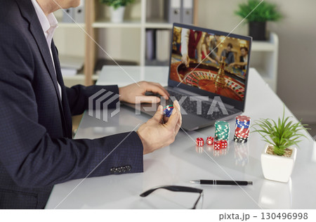 Close-Up Of Man Playing Online Casino With Chips 130496998