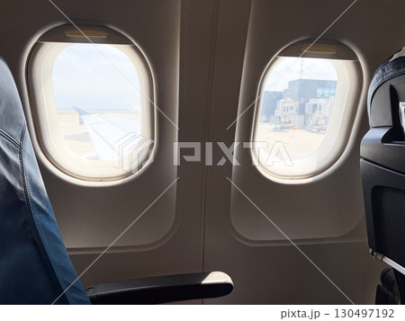 View from airplane window showing airport and aircraft outside. Travel, aviation, and mobility symbolizing journey, tourism, and modern transportation. View from airplane window showing airport and aircraft outside. Travel, aviation, and mobility symbolizing journey, tourism, and modern transportation. 130497192