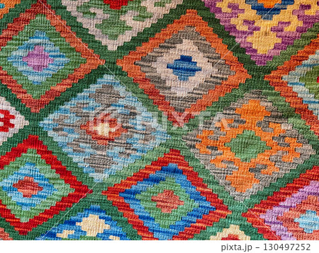 Colorful woven carpet with traditional geometric motifs and vibrant cultural ornament. Folk art, ethnic heritage, and handmade textile craft representing tradition and design. Colorful woven carpet with traditional geometric motifs and vibrant cultural ornament. Folk art, ethnic heritage, and handmade textile craft representing tradition and design. 130497252