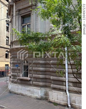 Historic stone building with decorated facade and arched window. Heritage architecture, cultural value, and urban history. Historic stone building with decorated facade and arched window. Heritage architecture, cultural value, and urban history. 130497272
