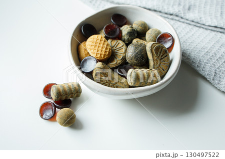 Different licorice candies in small bowl on white table close up Different licorice candies in small bowl on white table close up 130497522