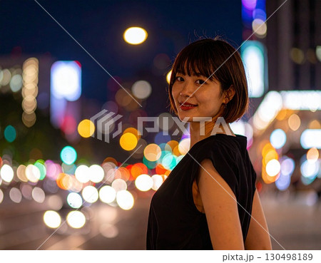 夜景をバックに立つ女性 130498189