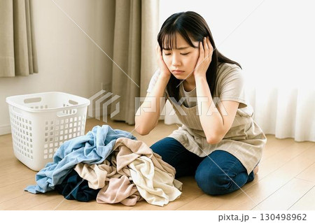 家事に疲れた女性の日常  掃除・洗濯・料理・片付けにうんざりする表情　洗濯物 130498962