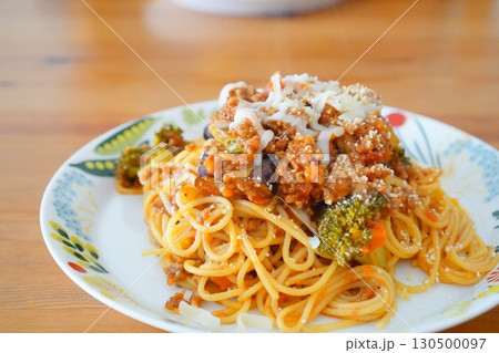ブロッコリーやナスが入った手作りミートソーススパゲッティを食卓で撮影した家庭料理 130500097