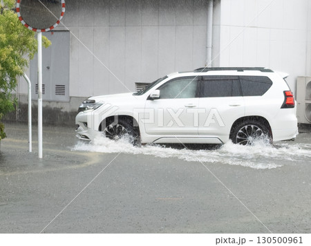 冠水した道路で車が水しぶきを上げながら走行する様子 冠水した道路で車が水しぶきを上げながら走行する様子 130500961