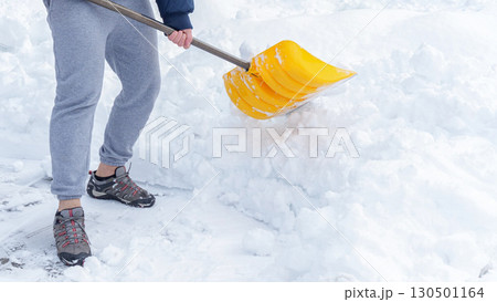 Man shoveling snow off of his driveway after a winter storm in Canada. Man with snow shovel cleans sidewalks in winter. Winter time. 130501164