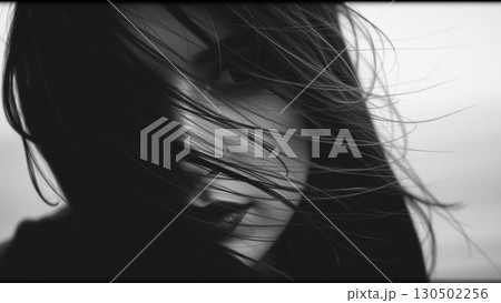 Monochrome portrait of a beautiful woman. Strong wind blows your hair 130502256