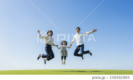 芝生の上でジャンプする家族 芝生の上でジャンプする家族 130502805