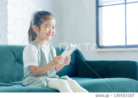 スマホを操作する小学生の女の子 130503107