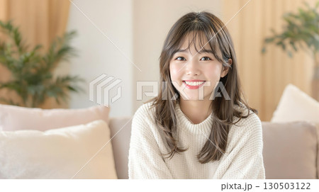 リビングで笑顔を浮かべる若い女性 130503122
