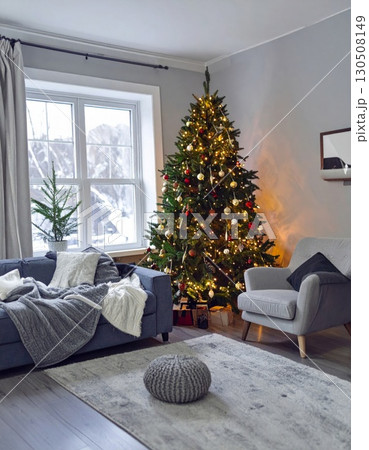Christmas Tree in Cozy Living Room with Gray Walls and Winter Scene Outside 130508149
