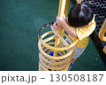 公園の遊具で遊ぶ黄色い服を着た小さな男の子 130508187