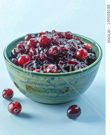 Cranberry Sauce in Blue Bowl with Red Berries and Textured Surface 130508299
