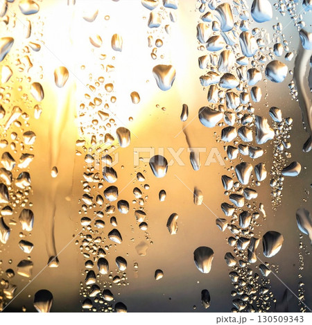 Close Up of Water Droplets on Glass Surface with Golden Light Background 130509343