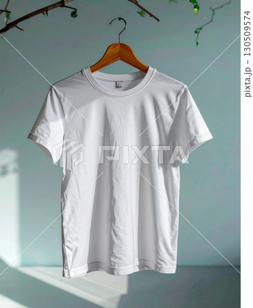 Crisp White T Shirt Hanging from Wooden Hanger with Plant Decor 130509574