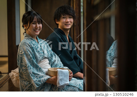 温泉旅館・宿坊・古民家の縁側で夕涼みする浴衣姿の夫婦・カップル 温泉旅館・宿坊・古民家の縁側で夕涼みする浴衣姿の夫婦・カップル 130510246