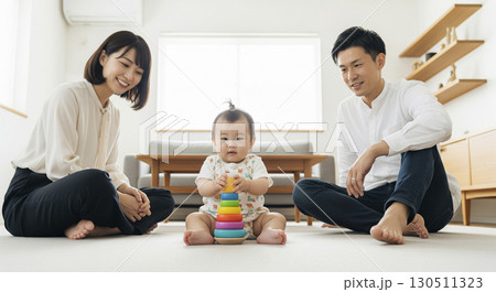 赤ちゃんを見守る夫婦　家族イメージ 130511323