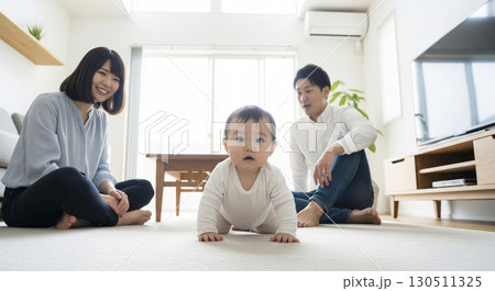 ハイハイする赤ちゃんを見守る夫婦 家族イメージ ハイハイする赤ちゃんを見守る夫婦 家族イメージ 130511325