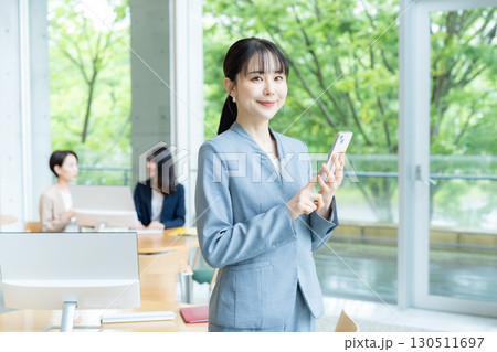 オフィスでスマホを操作するビジネスウーマン 130511697