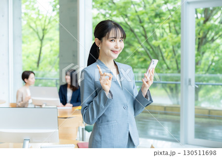 オフィスでスマホを操作するビジネスウーマン 130511698