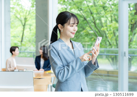 オフィスでスマホを操作するビジネスウーマン 130511699