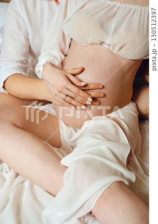 Couple enjoying intimate moment together while expecting their first child at home 130512397