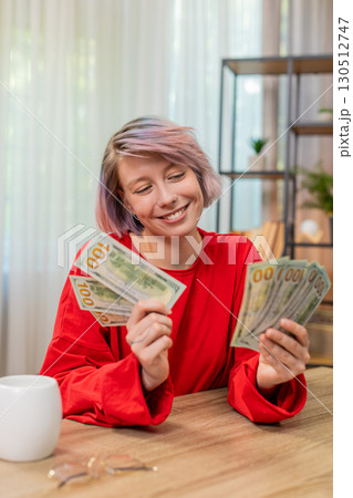 Woman happily counting dollars cash money, smiling, satisfied financial success and wealthy emotions 130512747