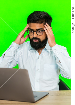 Arabian man looking at laptop with disappointment sad angry expression showing failure or bad result 130512810