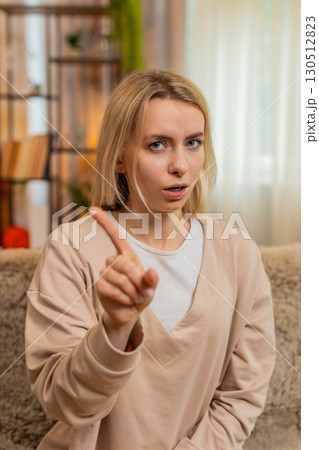 Adult woman shaking head at home clearly expressing disagreement or refusal with serious look Adult woman shaking head at home clearly expressing disagreement or refusal with serious look 130512823