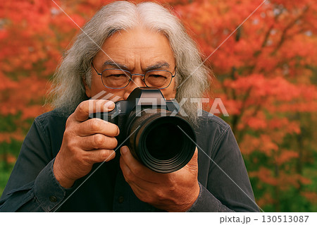 紅葉を撮影するシニアカメラマン 130513087