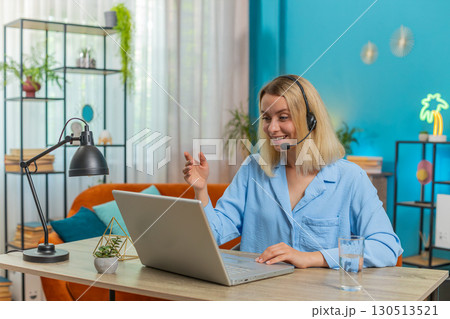 Businesswoman wearing headset support service operator helpline call center talking with client 130513521