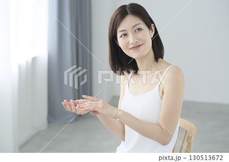 リビングで手のひらにクリームを乗せてスキンケアをする日本人女性 リビングで手のひらにクリームを乗せてスキンケアをする日本人女性 130513672