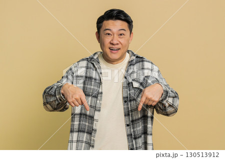Asian blogger man pointing down, saying to subscribe gesturing ok like showing place for information Asian blogger man pointing down, saying to subscribe gesturing ok like showing place for information 130513912