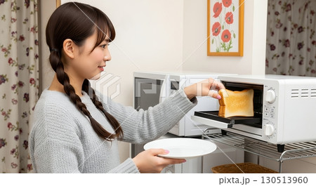 トースターからトーストを取り出す女性 130513960