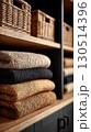 A rustic stack of cozy folded blankets in neutral tones. 130514396