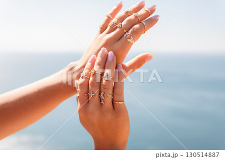 A woman is holding her hands up to show off her rings A woman is holding her hands up to show off her rings 130514887