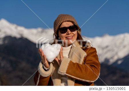 Snow Heart Mountains Woman: Winter joy, snowy landscape, woman holding heart-shaped snowball. Snow Heart Mountains Woman: Winter joy, snowy landscape, woman holding heart-shaped snowball. 130515001