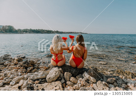 Watermelon Beach Summer: Two women enjoy red watermelon slices seaside vacation. 130515005